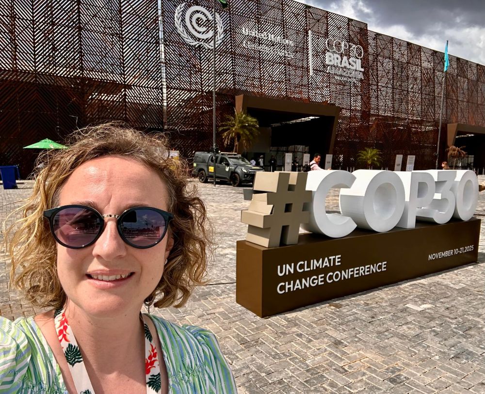 A woman standing in front of a COP30 sign